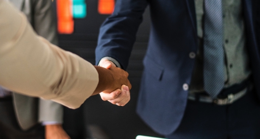 Man shaking hands across a table.