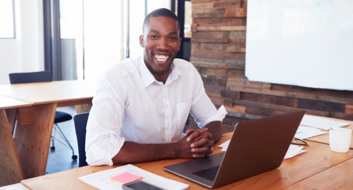 business man sitting at a desk with a laptop