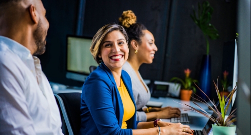 female business person smiling at coworker